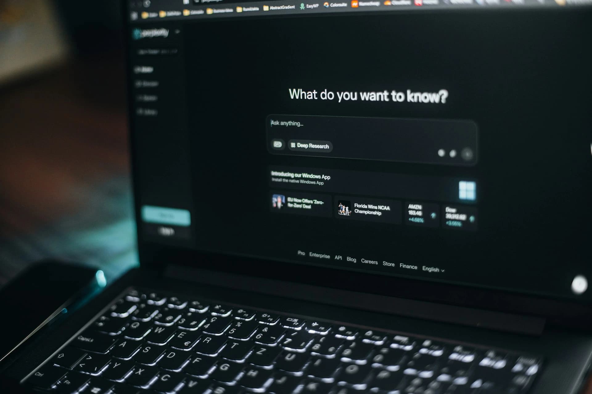 A laptop showing an AI search assistant asking what do you want to know.